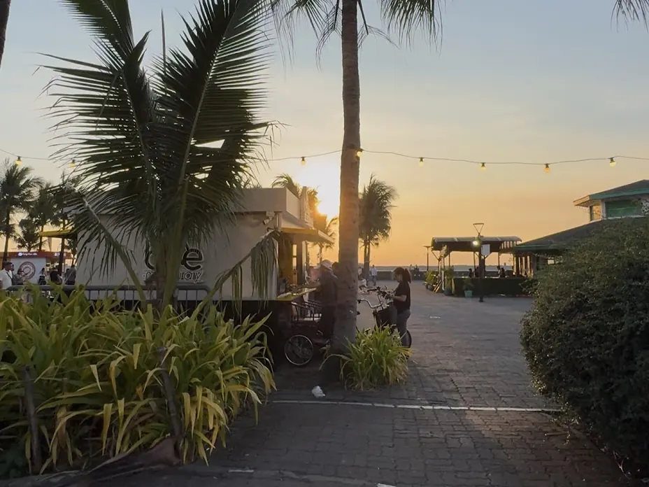 Palm trees and food stalls along Manila Baywalk at sunset